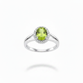 14K white gold oval peridot and diamond halo ring with high polish plain split shank suspended on white background