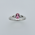 10K white gold oval pink tourmaline ring with diamond accents in open cutout shoulders suspended on white background