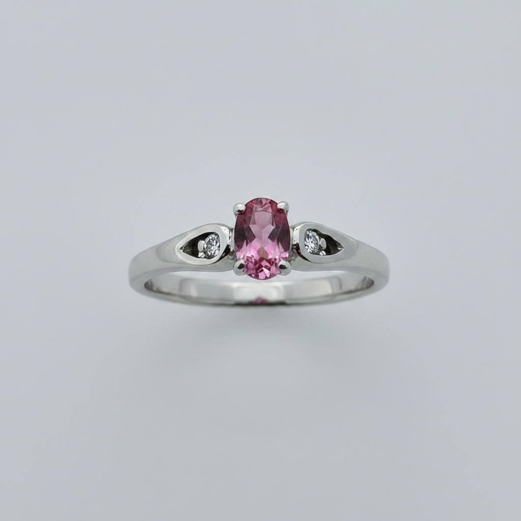 10K white gold oval pink tourmaline ring with diamond accents in open cutout shoulders suspended on white background