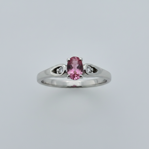 10K white gold oval pink tourmaline ring with diamond accents in open cutout shoulders suspended on white background