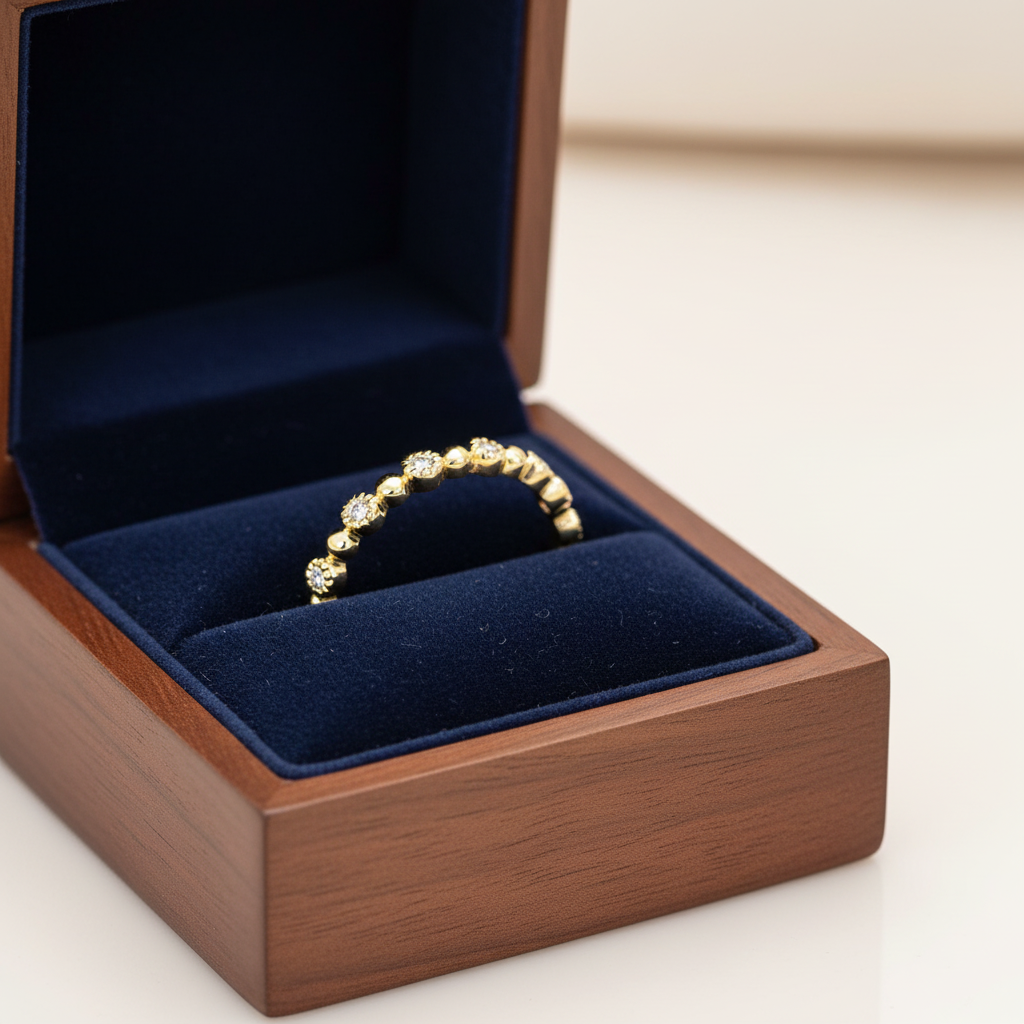 Low profile 14K yellow gold diamond wedding band displayed in a luxury velvet ring box