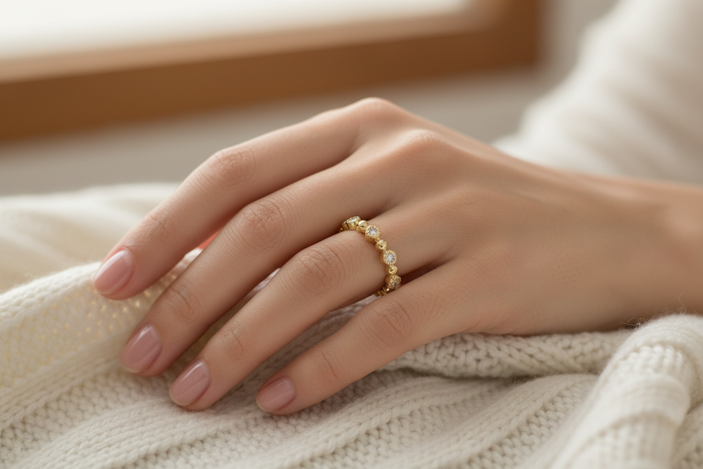 Low profile 14K yellow gold diamond wedding band worn on a woman's hand