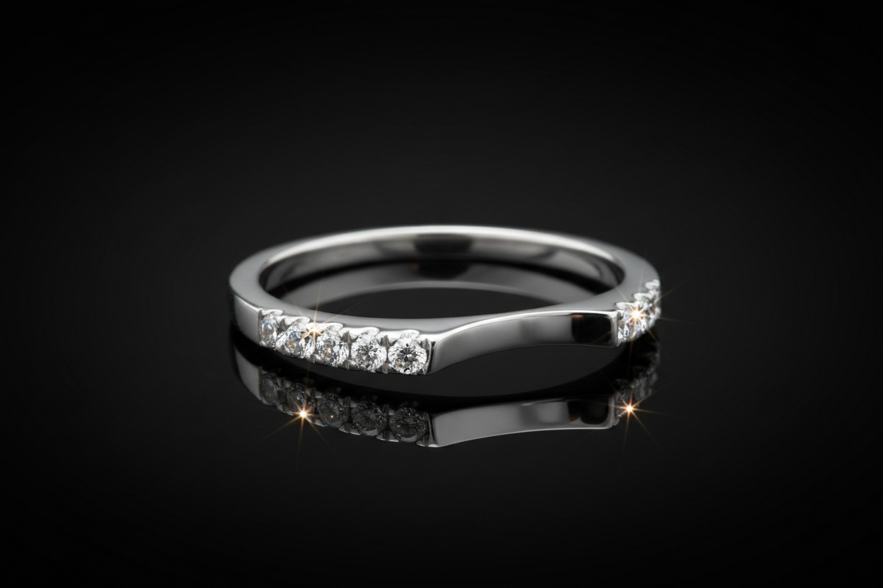 14K white gold curved diamond wedding band on dark background with dramatic studio lighting