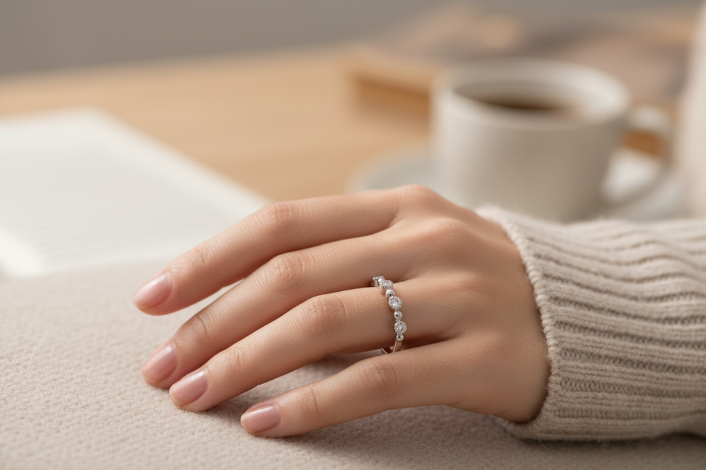Low profile 14K white gold diamond wedding band worn on a woman's hand