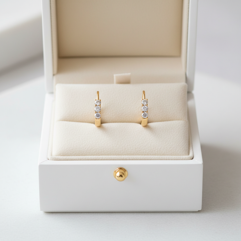 14K yellow gold diamond huggie hoop earrings displayed in an open luxury jewelry box