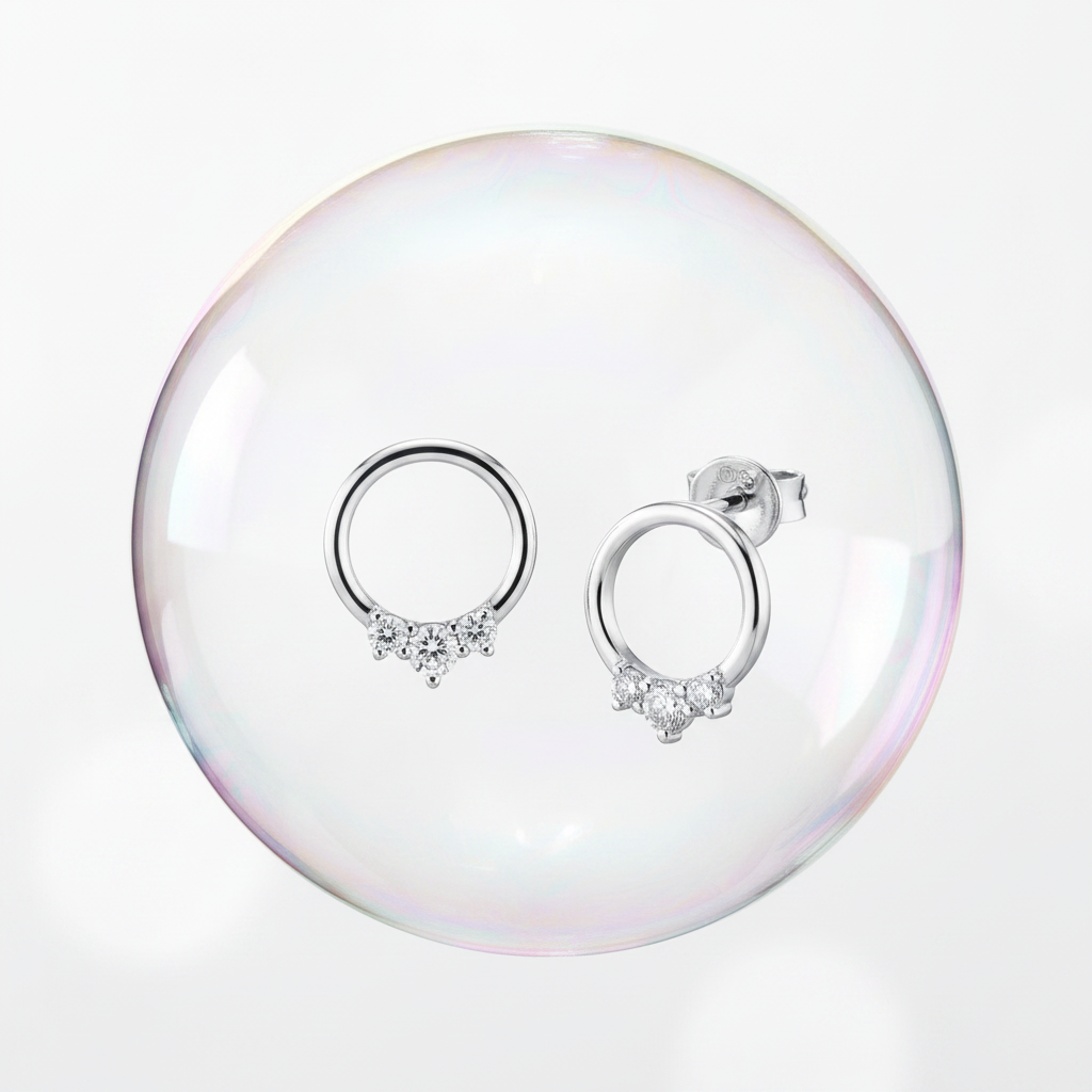 14K white gold three-diamond open circle stud earrings floating inside an iridescent soap bubble