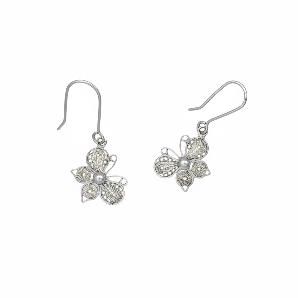 Sterling silver filigree butterfly drop earrings suspended on pure bright white seamless background, high-key professional jewelry photography