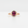 10K rose gold oval rhodolite garnet ring with diamond accents on white background