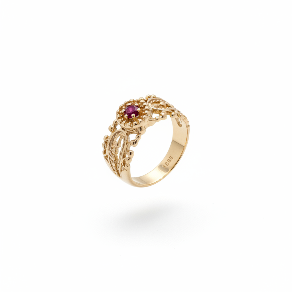 Ruby filigree band ring in 14kt yellow gold with tapered band, gold bead surround and open scrollwork, suspended on white background